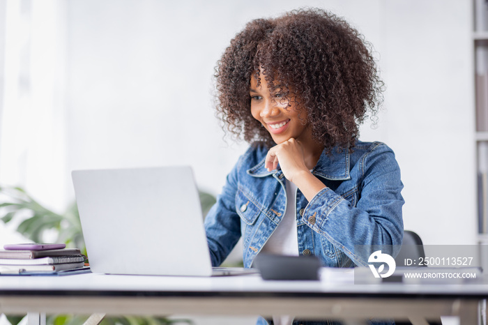 Creative young african american woman working on laptop in her studio,Doing accounting analysis report real estate investment data, Financial and tax systems concept.