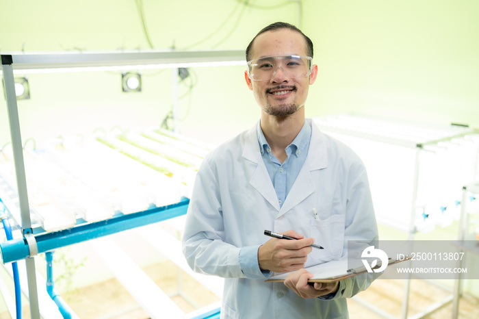 professional agriculture scientist working to research on a organic vegetable plant in laboratory greenhouse , development of smart technology for hydroponic growth farming indoor vertical farm