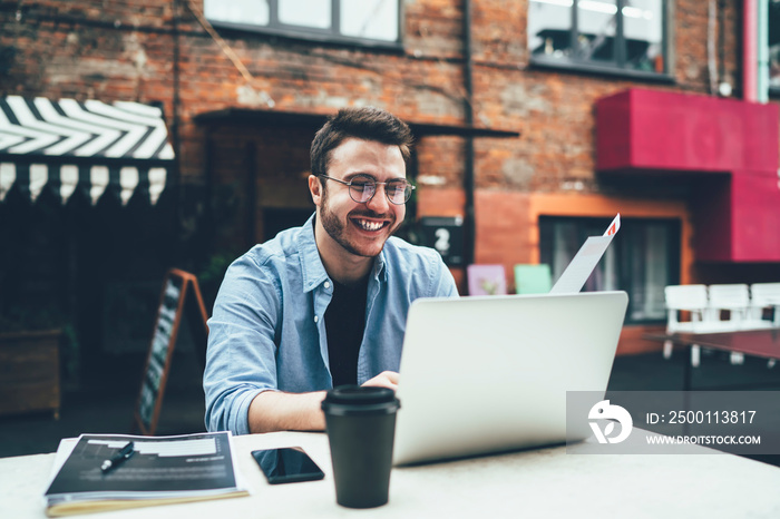 Excited remote worker watching laptop in street