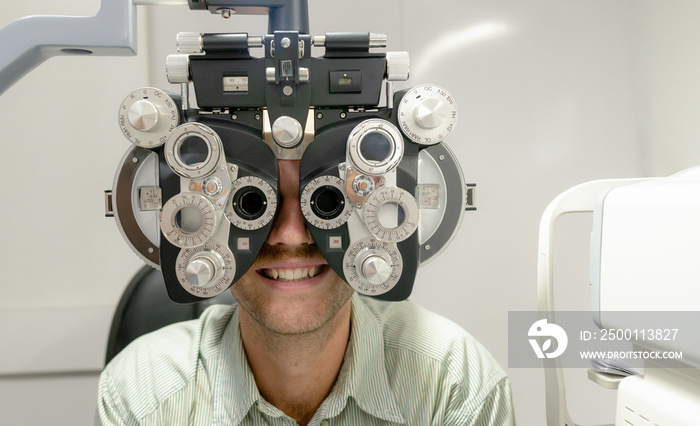 Young man checking his eyes to make glasses.