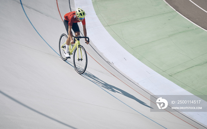 Top view of man in sports clothing cycling on track outdoors