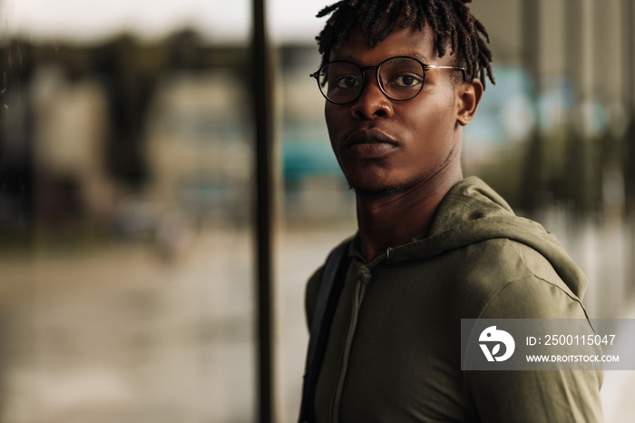 fashionable American man wearing stylish glasses smiling stylish young man in urban setting in the city