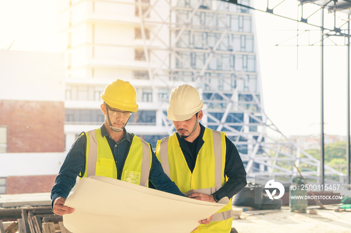 Team Civil Engineer and Contractor working with blueprint discussion planning on progress together at construction site.