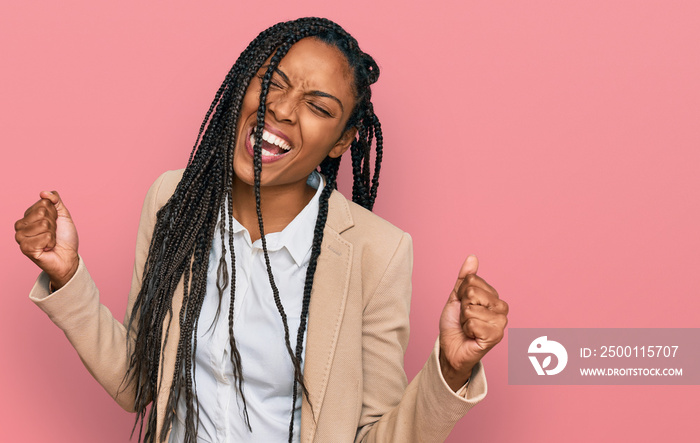 African american woman wearing business jacket very happy and excited doing winner gesture with arms raised, smiling and screaming for success. celebration concept.