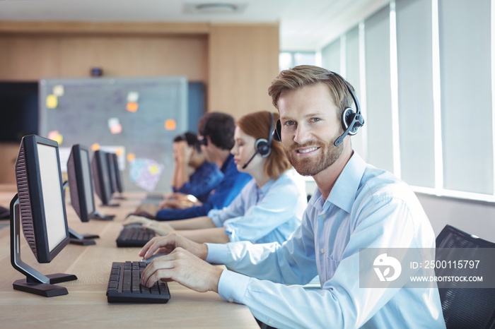 Portrait of smiling businessman working at call center