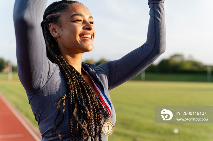 Portrait of female athlete celebrating with medal