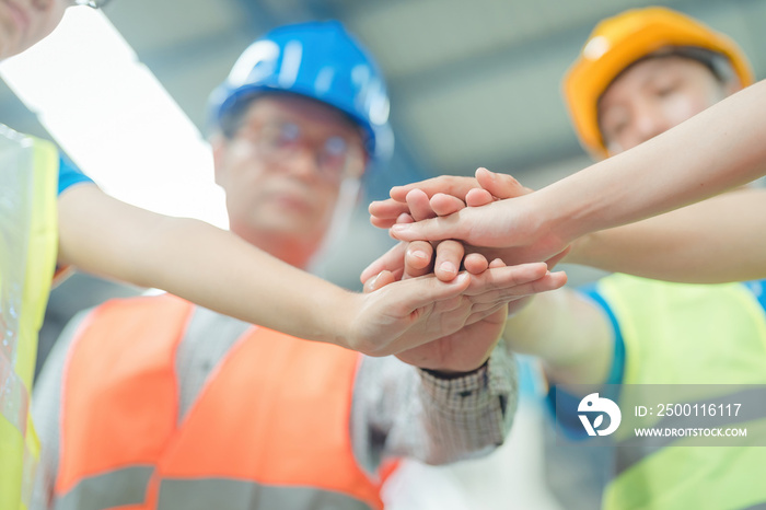 actory workers stacking hands together in warehouse or storehouse . Logistics , supply chain and warehouse business concept ..