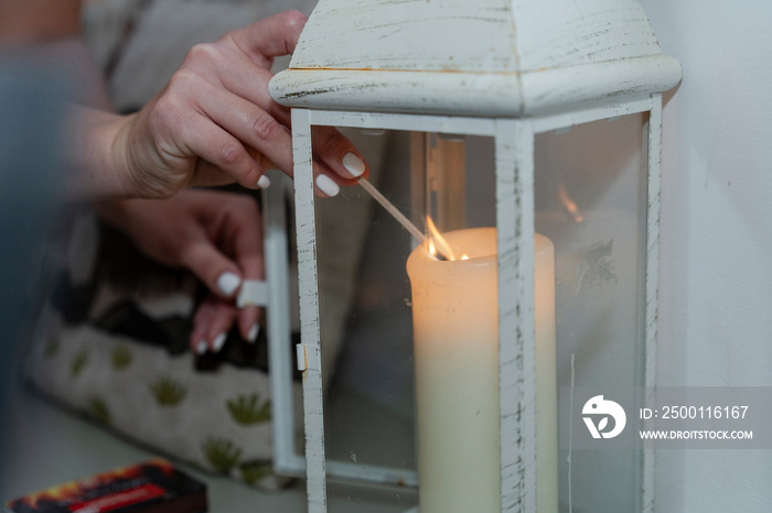 Woman igniting candle in lantern