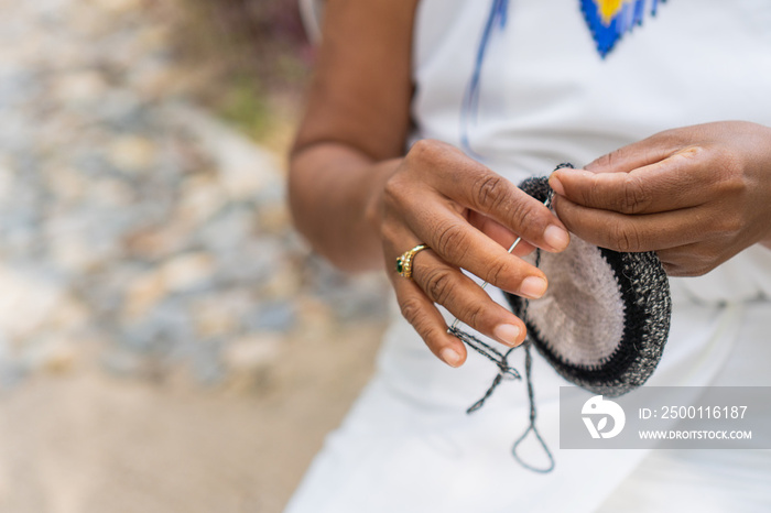 Unrecognizable Colombian weaver in traditional clothing. Precious close-up shot of a woman’s hands in the Sierra Nevada de Santa Marta making handmade products.