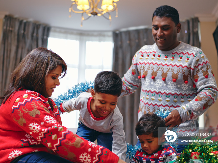 Parents and sons playing with Christmas decorations