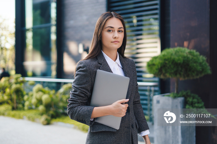 Young caucasian business lady economist with a laptop going to the office. Business meeting. Beautiful young girl.