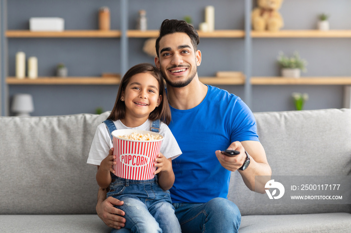 Happy loving family watching television sitting on couch