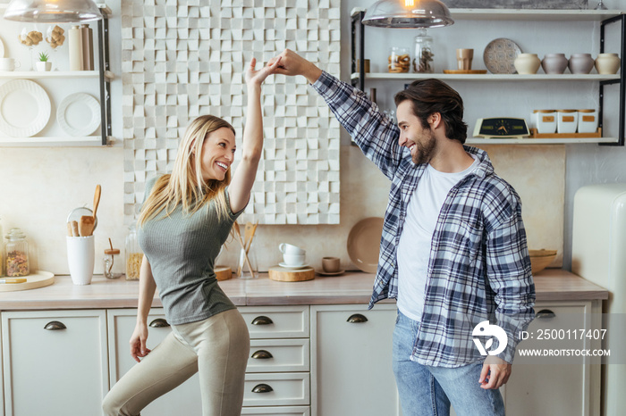 Satisfied european millennial man with stubble and blonde lady enjoy free time, have fun and dance