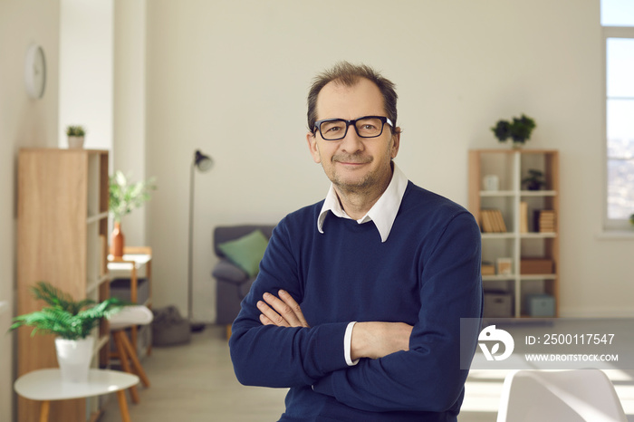 Confident experienced professional. Portrait of a smiling senior businessman in casual clothes and glasses in the office. Friendly office worker or company manager working in modern business center.