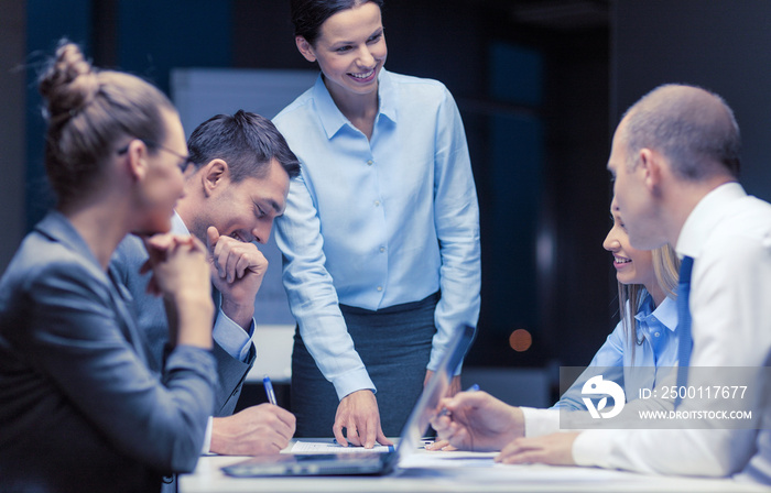 smiling female boss talking to business team