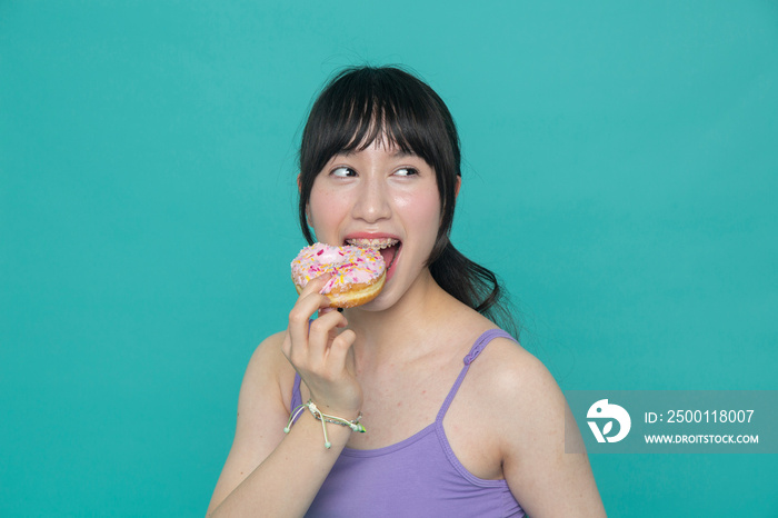 Studio portrait of girl eating donut