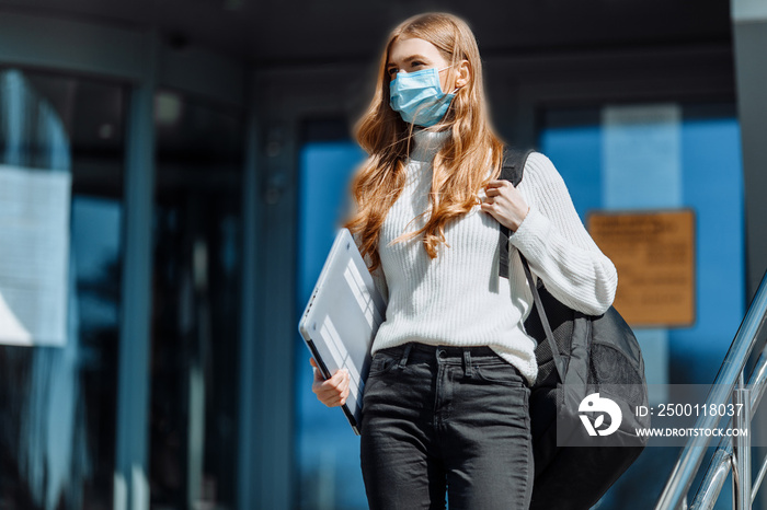 Beautiful young girl in a mask from coronovirus, student on the background of educational envy, women returning from work