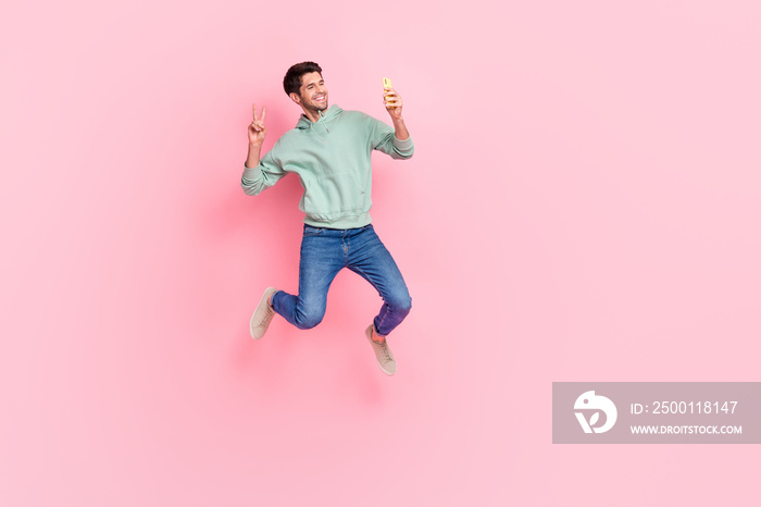 Full length photo of attractive cheerful blogger user make video record self portrait v-sign empty space isolated on pink color background