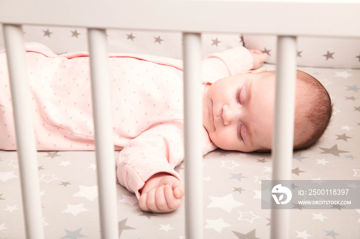 Cute baby sleeping in a white crib