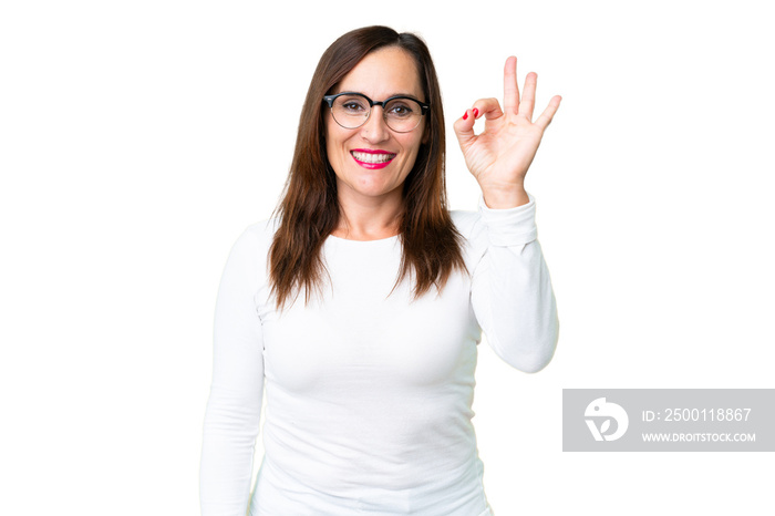 Middle age woman over isolated chroma key background showing ok sign with fingers