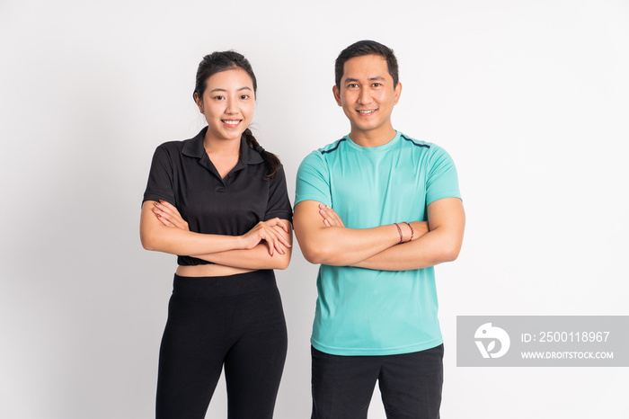 smiling asian woman and man standing with hands crossed on isolated background