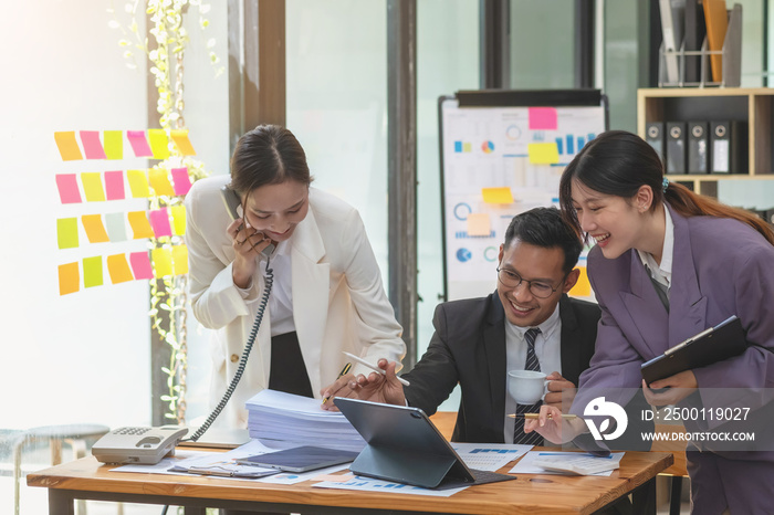 Asian business team consists of marketing staff. accountant and financial officer Help each other analyze company profits using tablets. calculator Laptop computers, graph paper, and corporate pens.