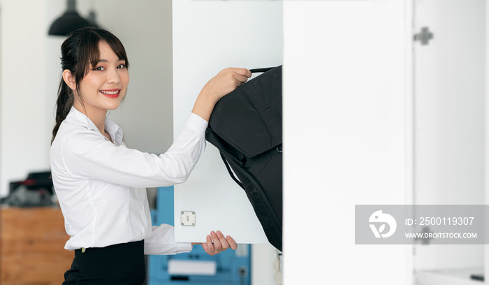 woman picking up the backpack from the locker .