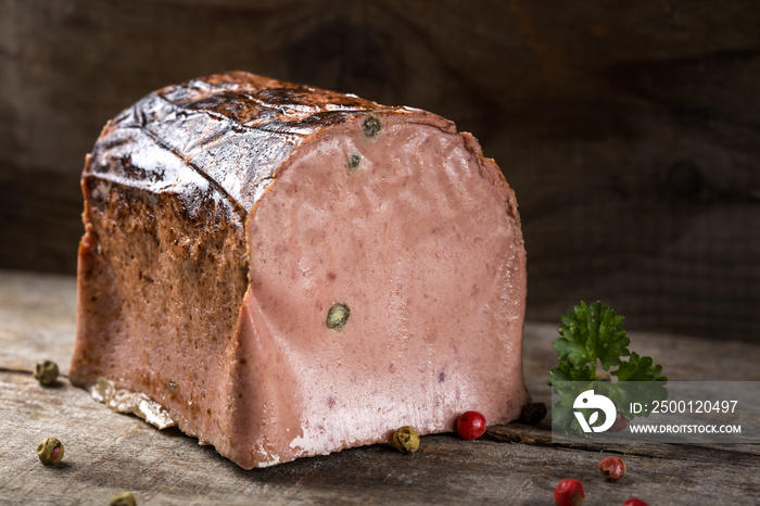 Special liver pate made from different types of meat with peppercorns on wood