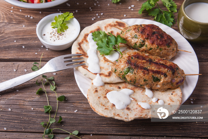 Kofta with flatbread on plate with salad