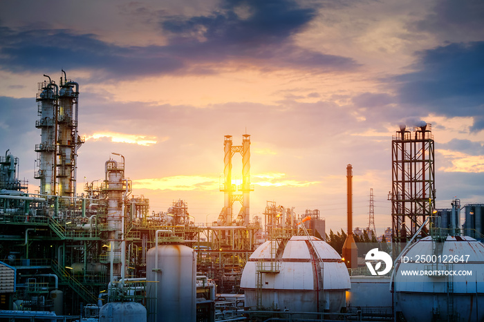 Manufacturing of oil and gas refinery industrial or Petrochemical industry plant on sunset sky background with smoke stacks and gas sphere tanks