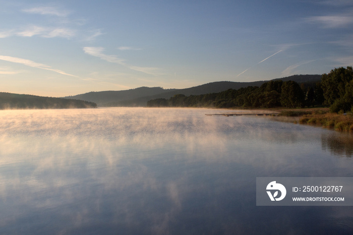 Sunrise over the lake in fog, summer morning, forest in the background, Predni Vyton, Lipno lake, Czech republic