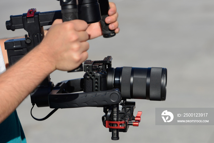 videographer shoots video with mirrorless camera with stabilizer