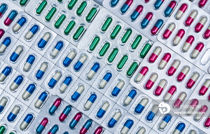 Full frame of colorful antimicrobial capsule pills. Quality control error in pharmaceutical manufacturing. Blister pack missing one capsule of antibiotic pill. Drug resistance concept.