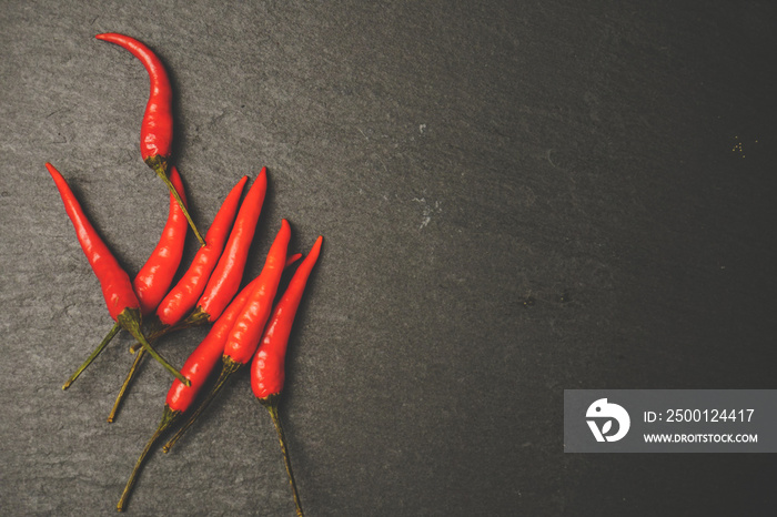 Chillies on slate, stone grunge texture. Vintage tone. Food Copy Space