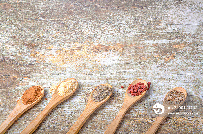 Various species in wooden spoons on rustic background