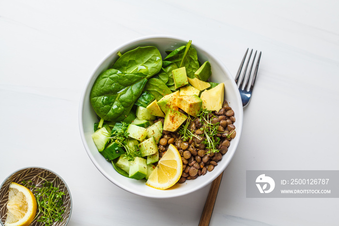 Green salad with spinach, lentils, avocado and cucumber.