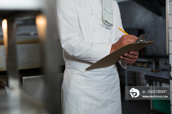 Male chef writing order on a clipboard