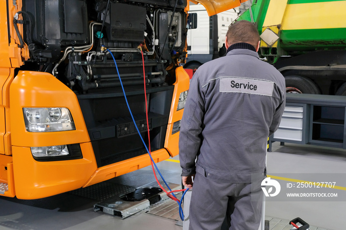 Truck on computer diagnostics in a car service. Servicing and repairing trucks in a large garage. Car service, repair, logistics and transport