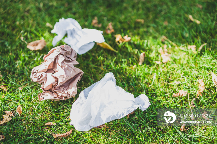 plastic bags and litter abandoned on green lawn, respecting the environment and avoiding single-use plastic