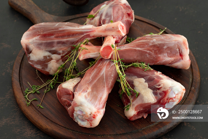 raw lamb shank on dark background