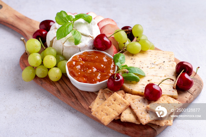 Healthy mediterranean cheese and fruits board on light background