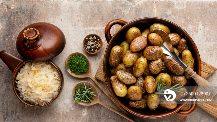 Pan filled with roasted potatoes shot on rustic wooden table.