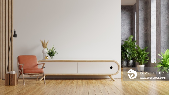 Leather armchair and a wooden cabinet in living room interior with plant,White wall.