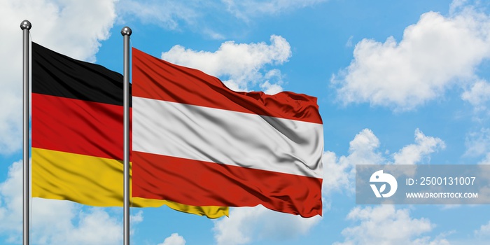 Germany and Austria flag waving in the wind against white cloudy blue sky together. Diplomacy concept, international relations.