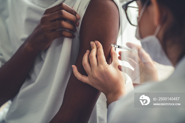 Young man visits skillful doctor at hospital for vaccination . Covid 19 and coronavirus vaccination center service concept .