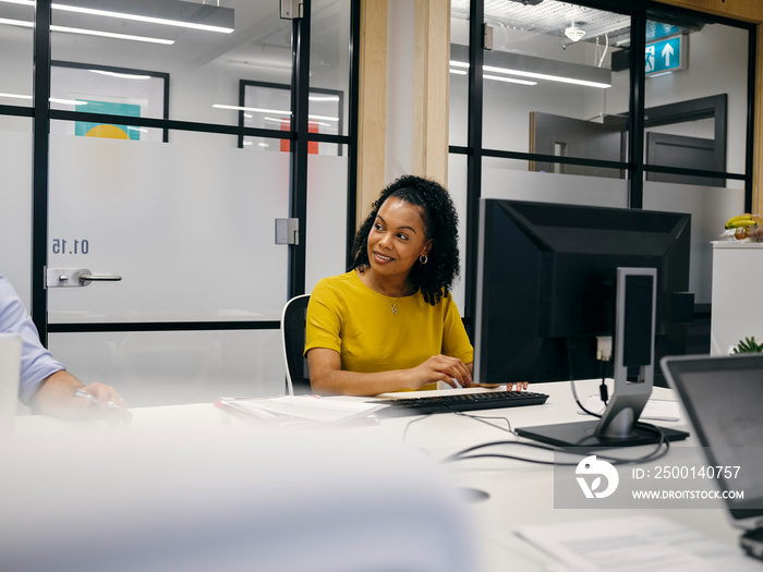 Office workers using computers in co-working office space