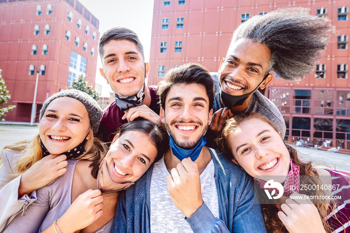 Multiracial friends taking selfie with opened face mask at college campus - Happy friendship concept with young students having fun together after university reopening - Bright backlight filter