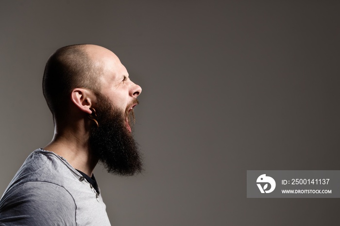 Side view portrait of screaming bearded man