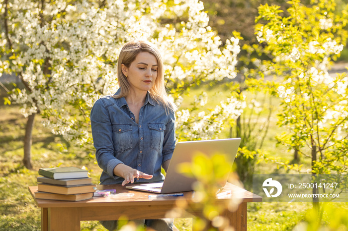 Amused blonde woman working with her notebook outdoor