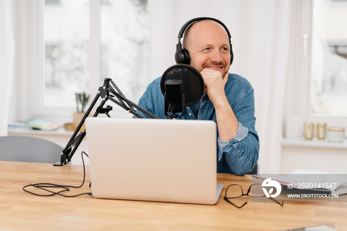 Man recording a podcast with a happy smile